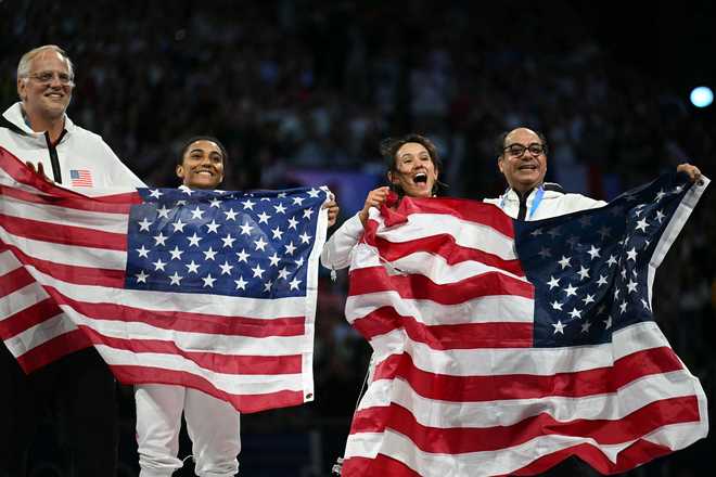 Silver medallist US' Lauren Scruggs (2ndL) and Gold medallist US' Lee Kiefer celebrate after winning in the women's foil individual gold medal bout during the Paris 2024 Olympic Games at the Grand Palais in Paris, on July 28, 2024. (Photo by Fabrice COFFRINI / AFP) (Photo by FABRICE COFFRINI/AFP via Getty Images)