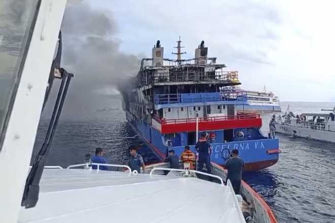 In this photo made from video released by the Indonesian National Search and Rescue Agency (BASARNAS), rescue ship approach passenger ship KM Barcelona after it caught fire in the waters off Talise Island in North Sulawesi, Indonesia.